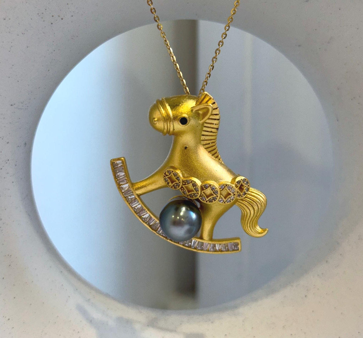 Tahitian pearl pendant brooch combining a playful horse design with sparkling clear accents.