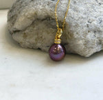 Rose raspberry pearl necklace and hook earrings with reflective surfaces.