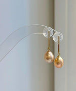Matching pearl jewelry set featuring warm peach gold tones and reflective luster.