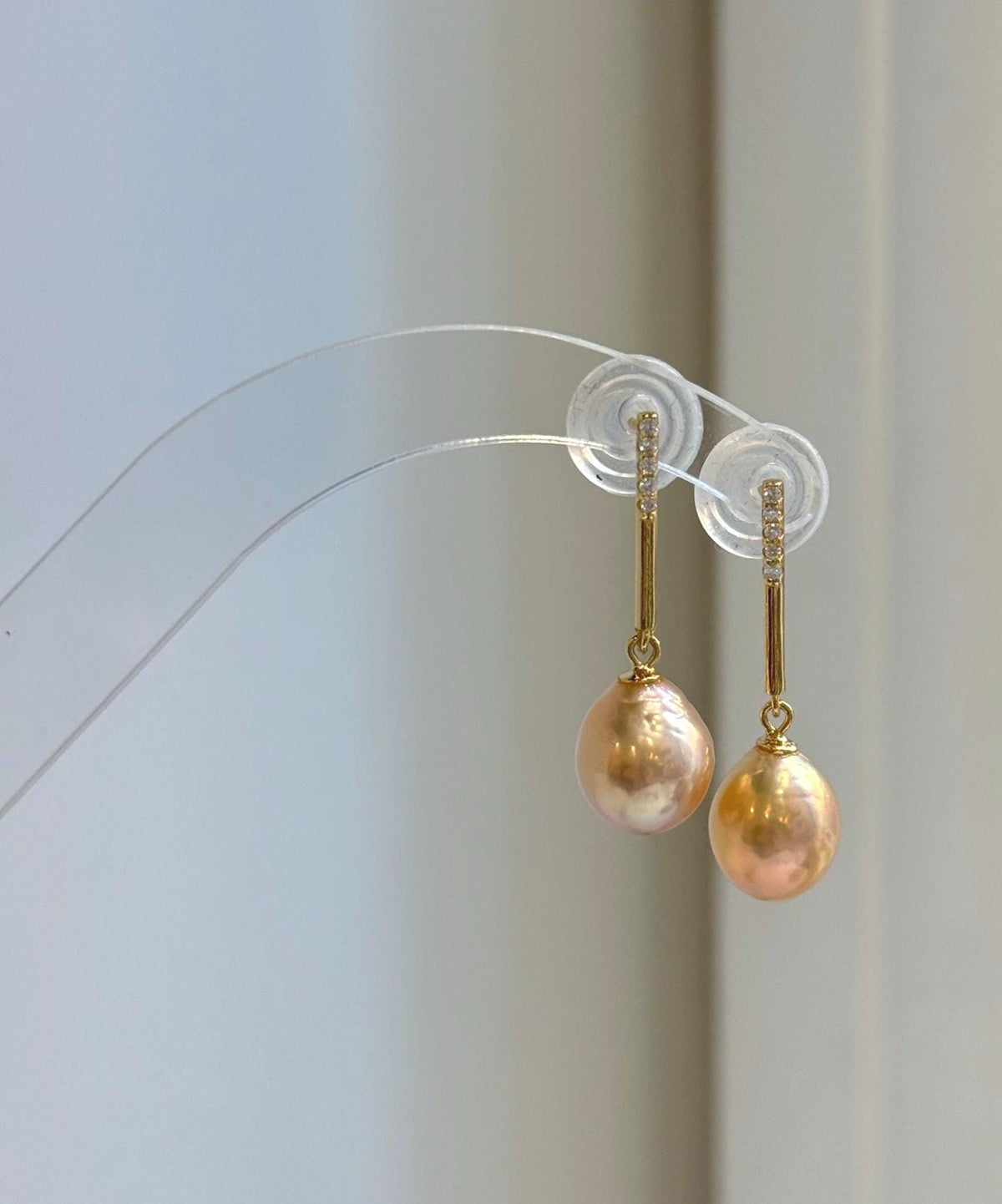 Matching pearl jewelry set featuring warm peach gold tones and reflective luster.