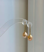 Coordinating pearl necklace and earrings with peach gold coloring and mirror luster.