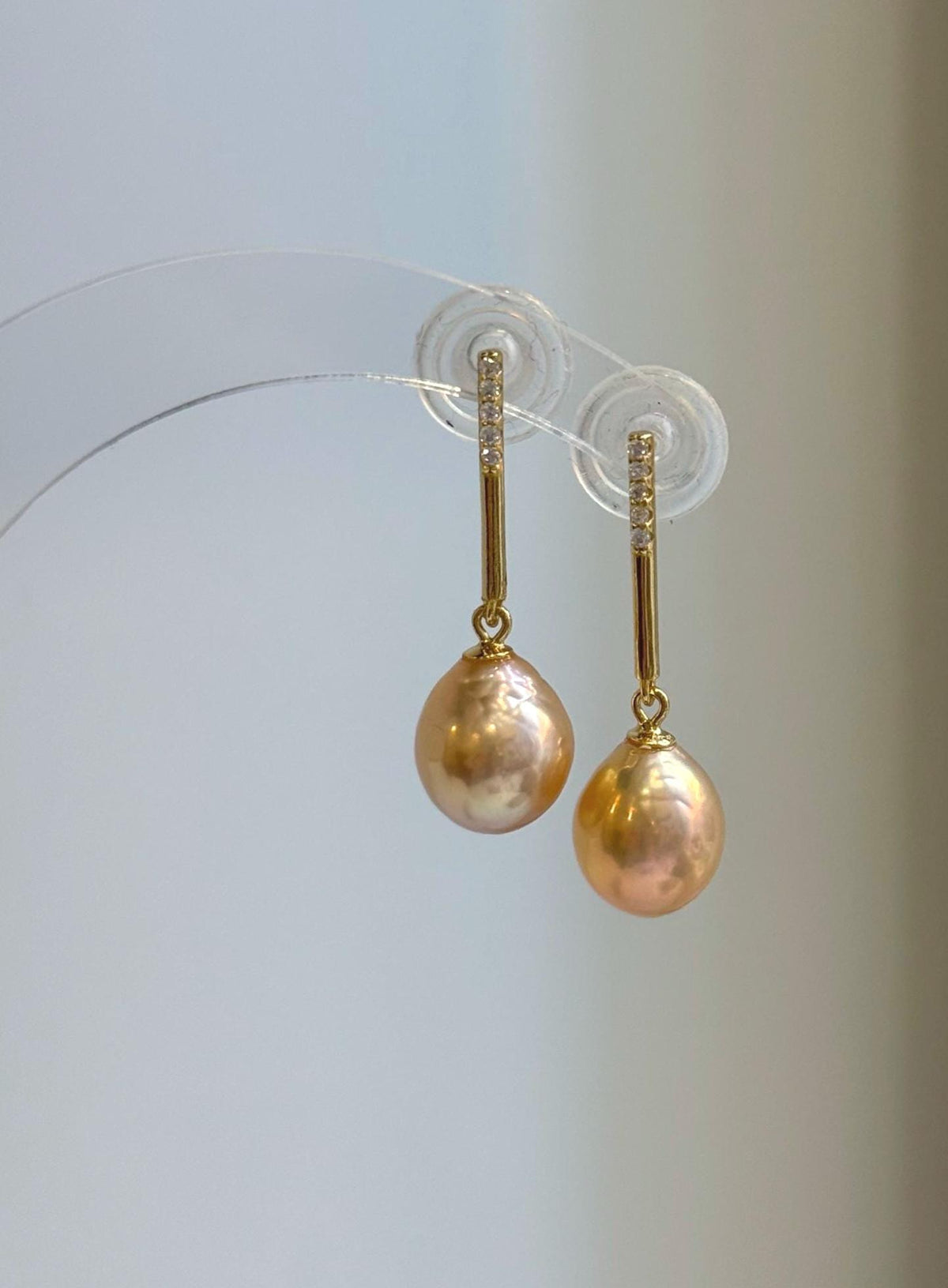 Peach gold pearl jewelry set featuring a pendant necklace and matching earrings.