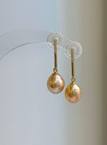 Peach gold pearl jewelry set featuring a pendant necklace and matching earrings.