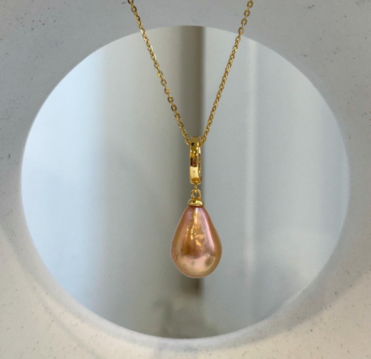 Warm peach and golden tones shimmer across the reflective pearl surfaces.