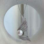 Silver-tone pearl brooch with rows of clear stones along flowing wings.