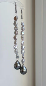 Green Tahitian pearl earrings with mirror luster and a dangling chandelier design.