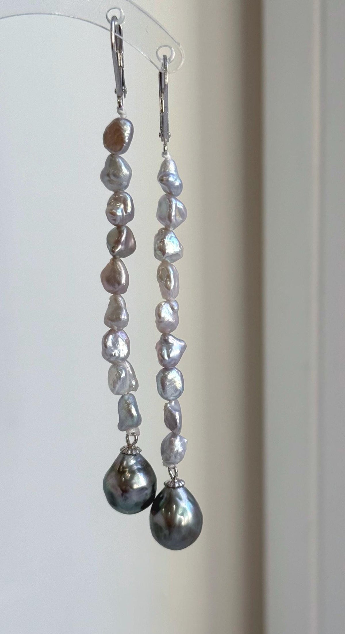 Green Tahitian pearl earrings with mirror luster and a dangling chandelier design.
