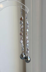 Genuine saltwater pearl earrings with silver leverback closures and green overtones.