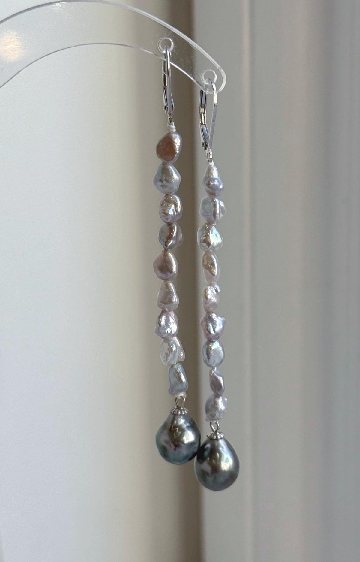Genuine saltwater pearl earrings with silver leverback closures and green overtones.