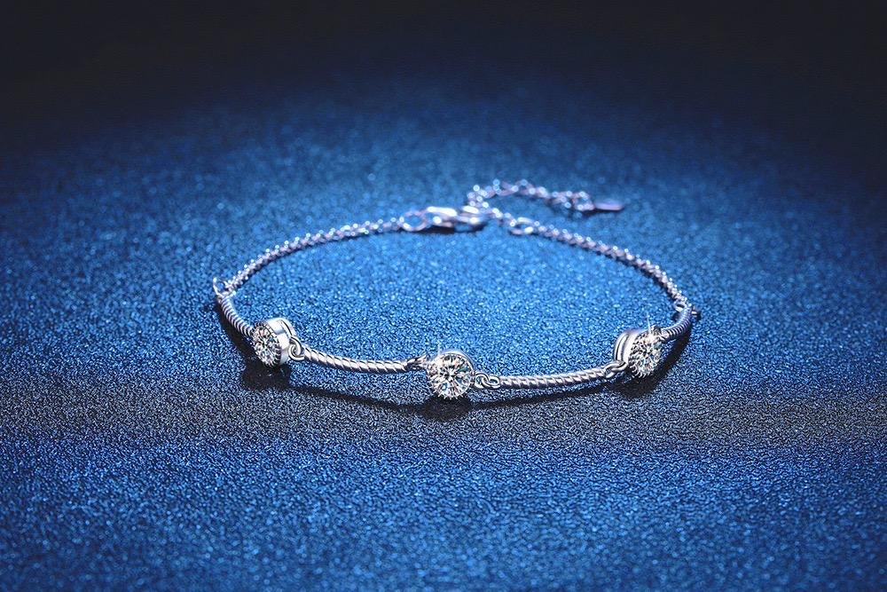 Silver bracelet featuring three bezel-set round moissanite stones