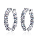 S925 sterling silver moissanite hoop earrings displayed on a textured blue background.