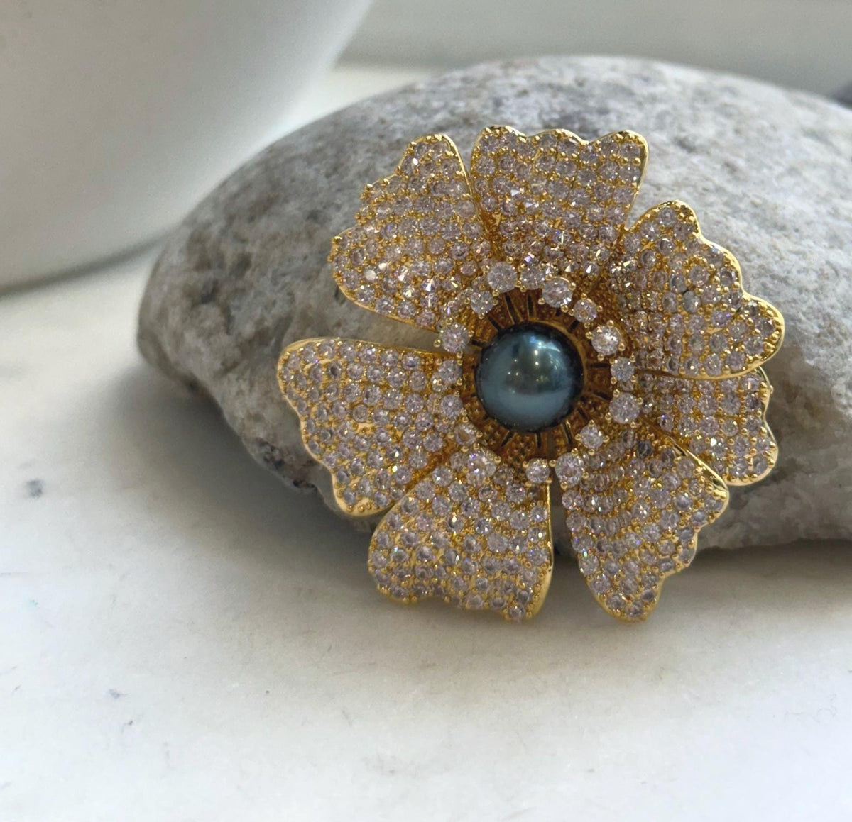 Lustrous hunter blue Tahitian pearl in a flower-inspired brooch pendant