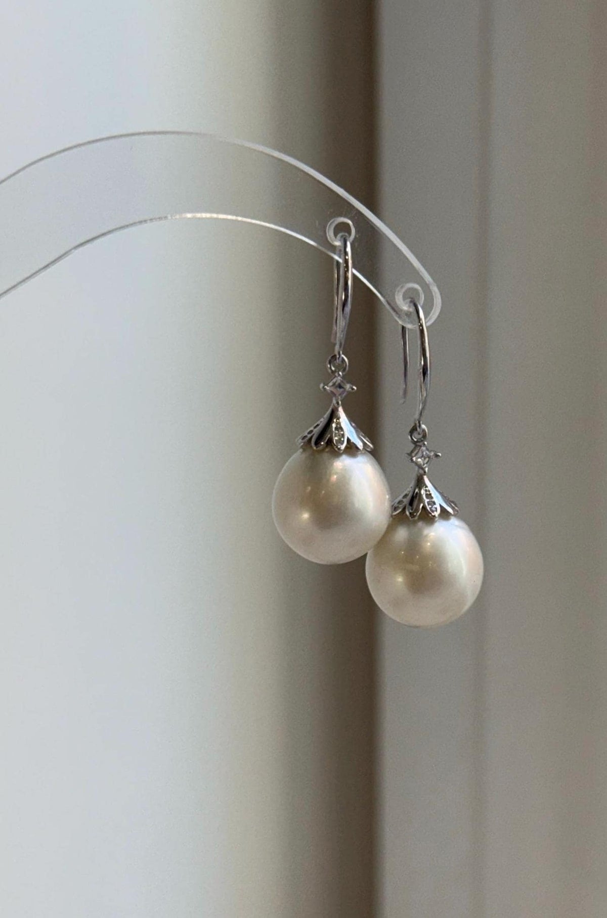 13.3mm white saltwater pearls featured in sterling silver drop earrings.