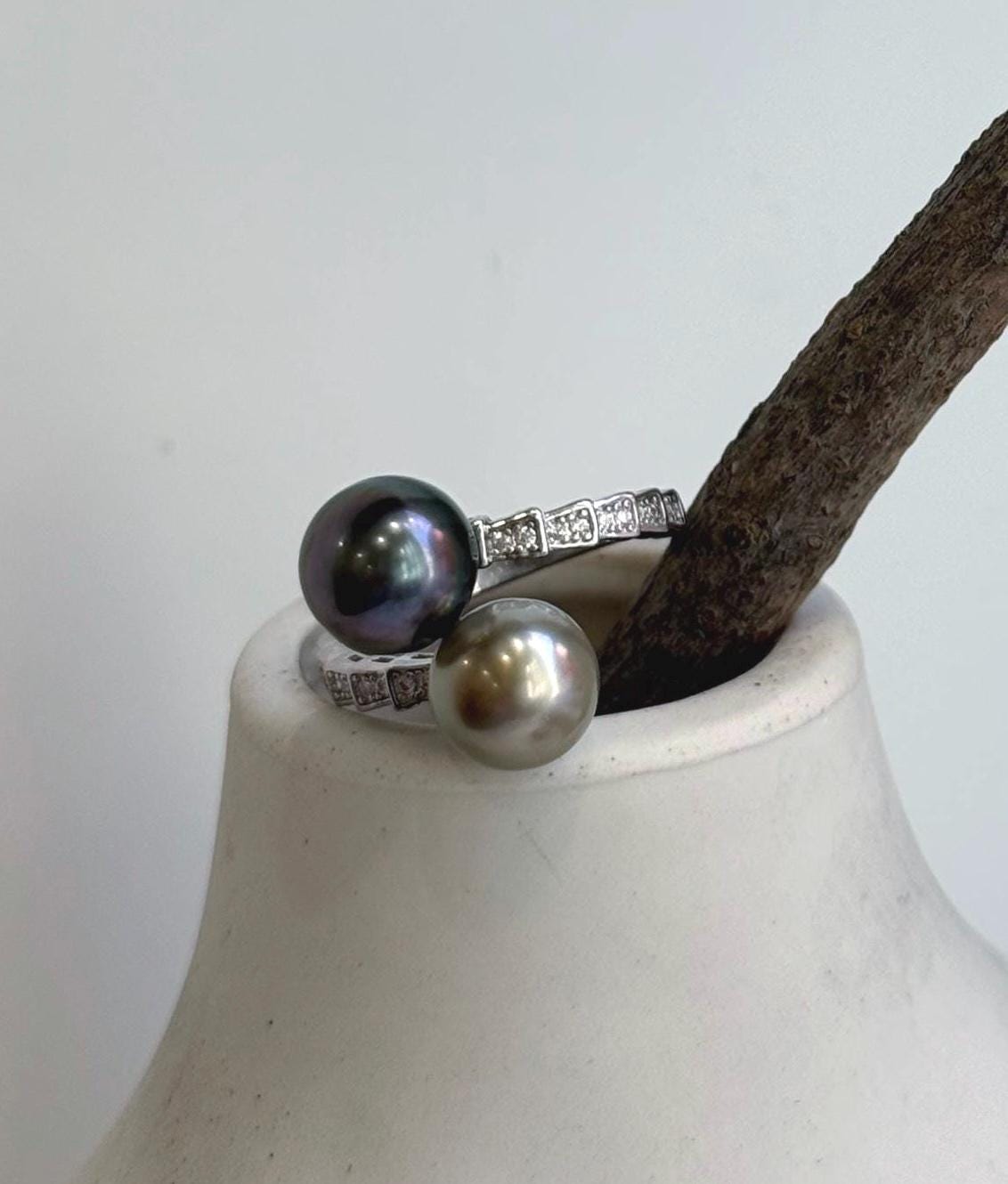 Sterling silver double pearl ring highlighting the reflective surfaces of Tahitian pearls.