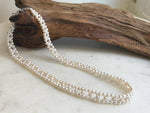 Close-up of 4–4.5mm white pearls with soft iridescent reflections.