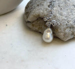 13.2x18.7mm white ocean pearl beneath a sparkling silver butterfly.