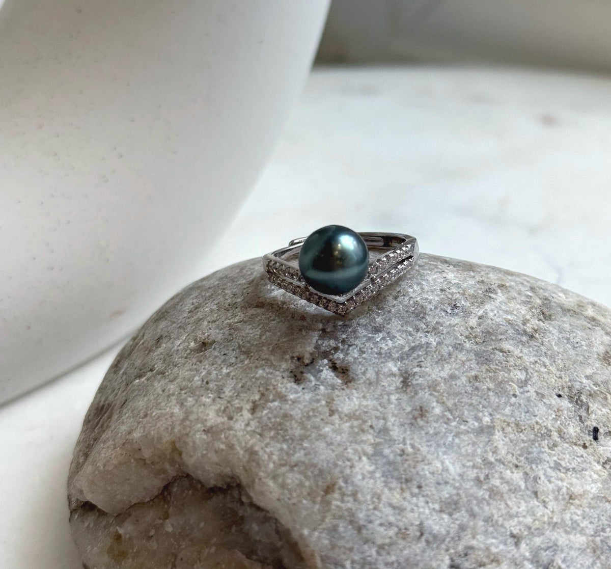 Peacock green Tahitian pearl above a V-shaped sterling silver setting.