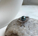 Dark peacock green saltwater pearl framed by a sparkling chevron band.