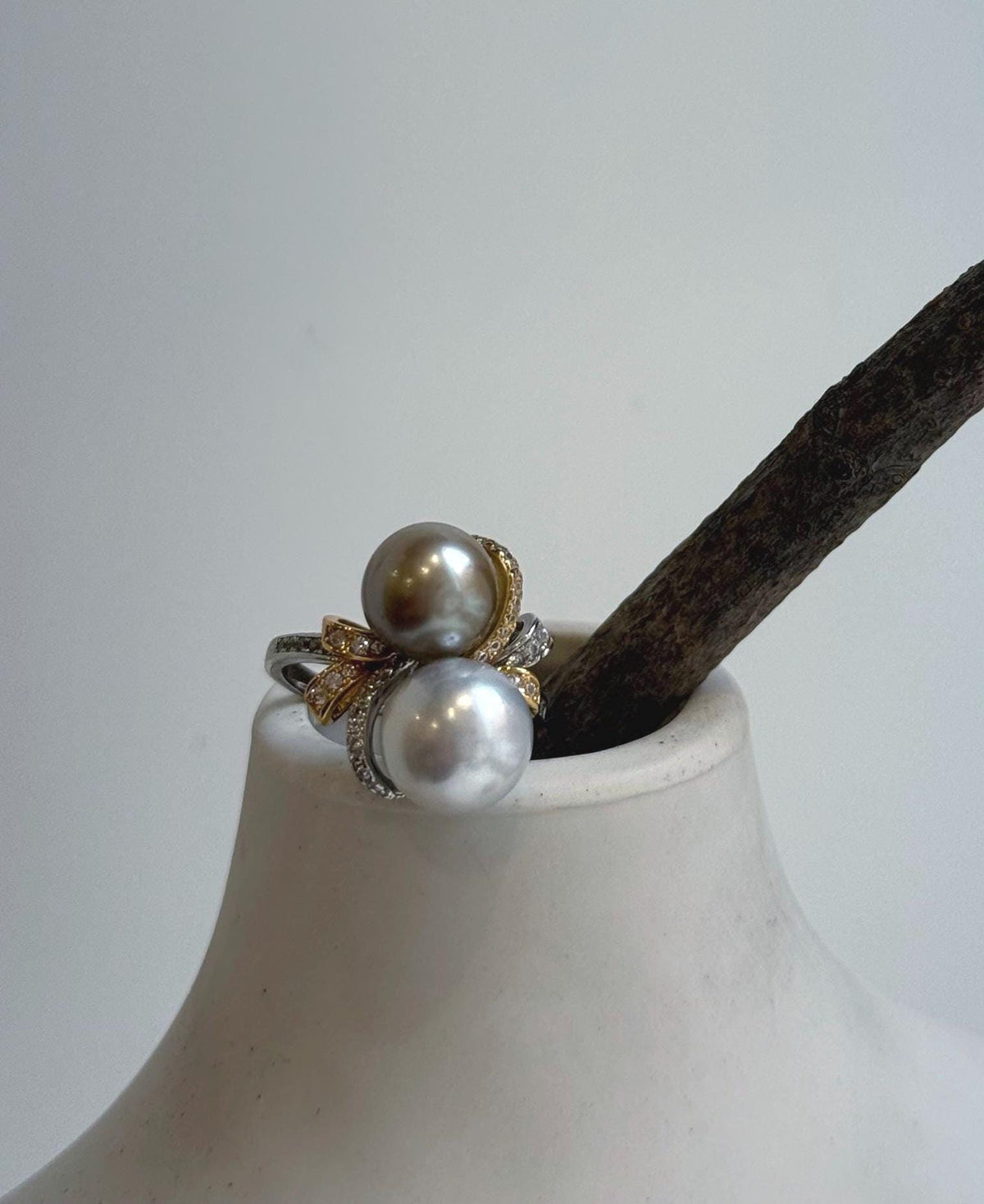 Two lustrous silver taupe pearls featured in an adjustable floral ring.